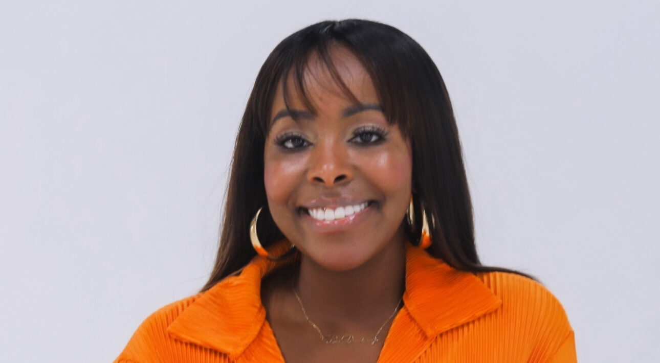 Woman smiling, wearing an orange blouse