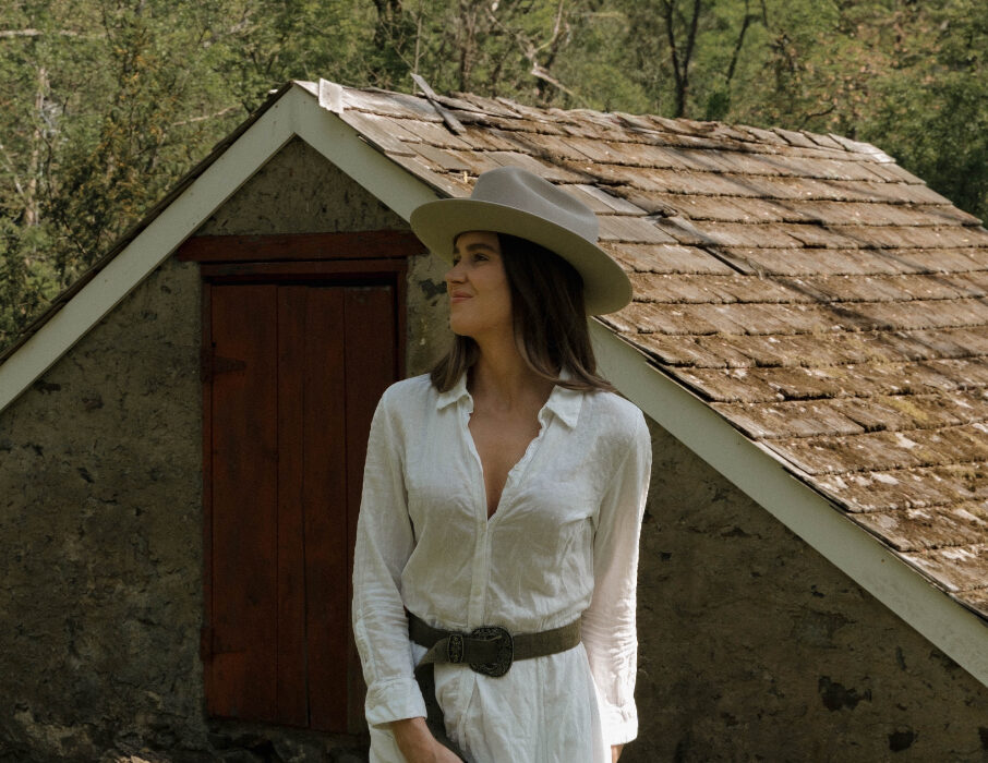 Woman in a white dress with a hat looking into the distance